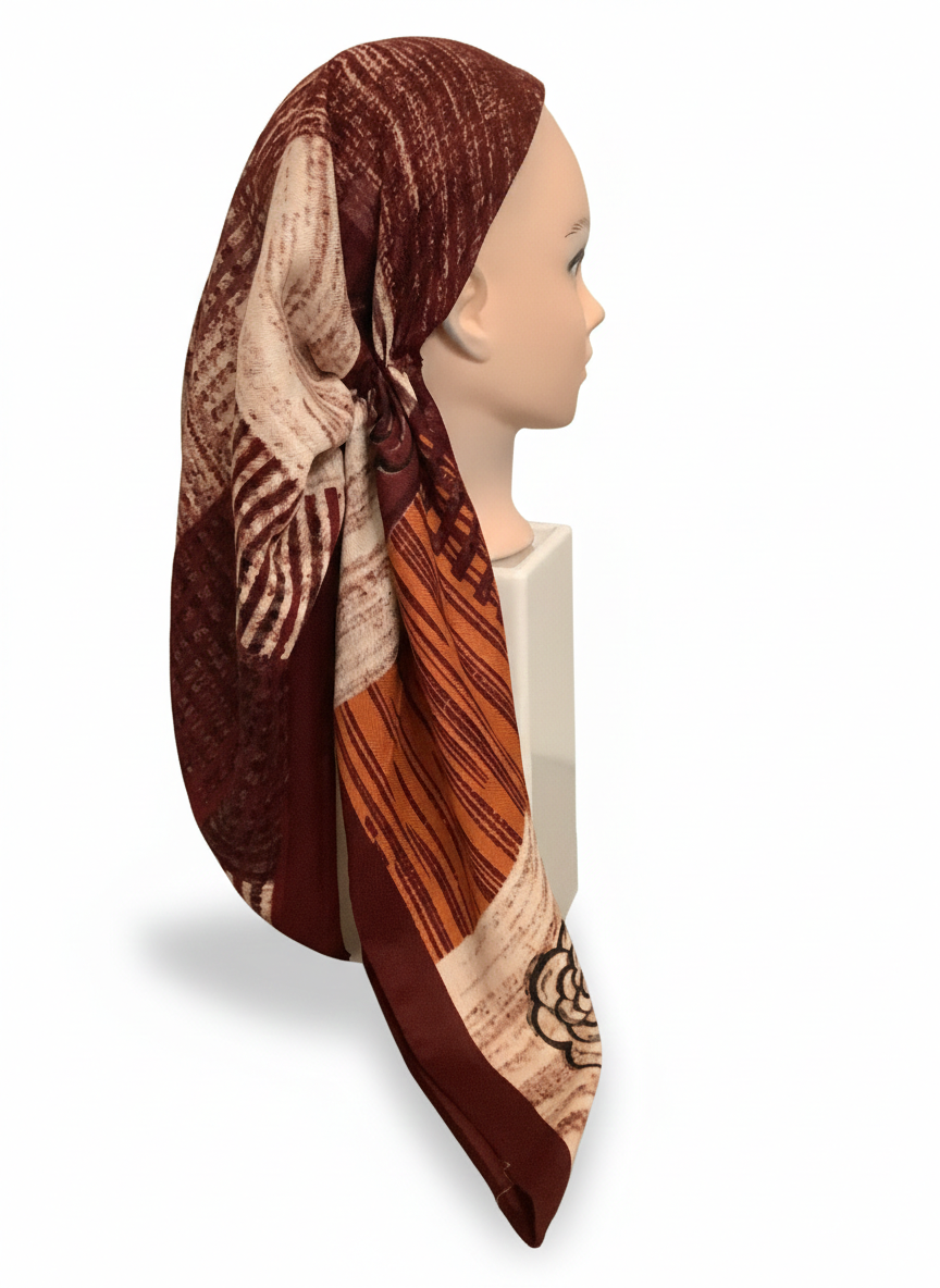 Mannequin head wearing a patterned headscarf on a white background