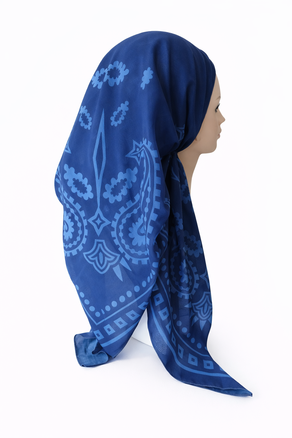 Blue patterned headscarf worn by a person on a white background