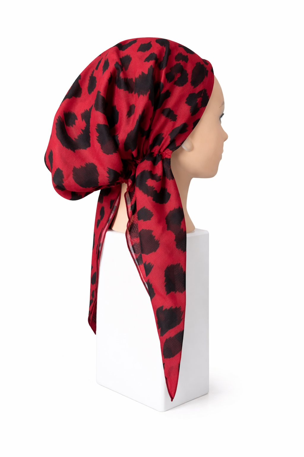 Red short-tail pretied tichel with black leopard print on a mannequin head against a white background