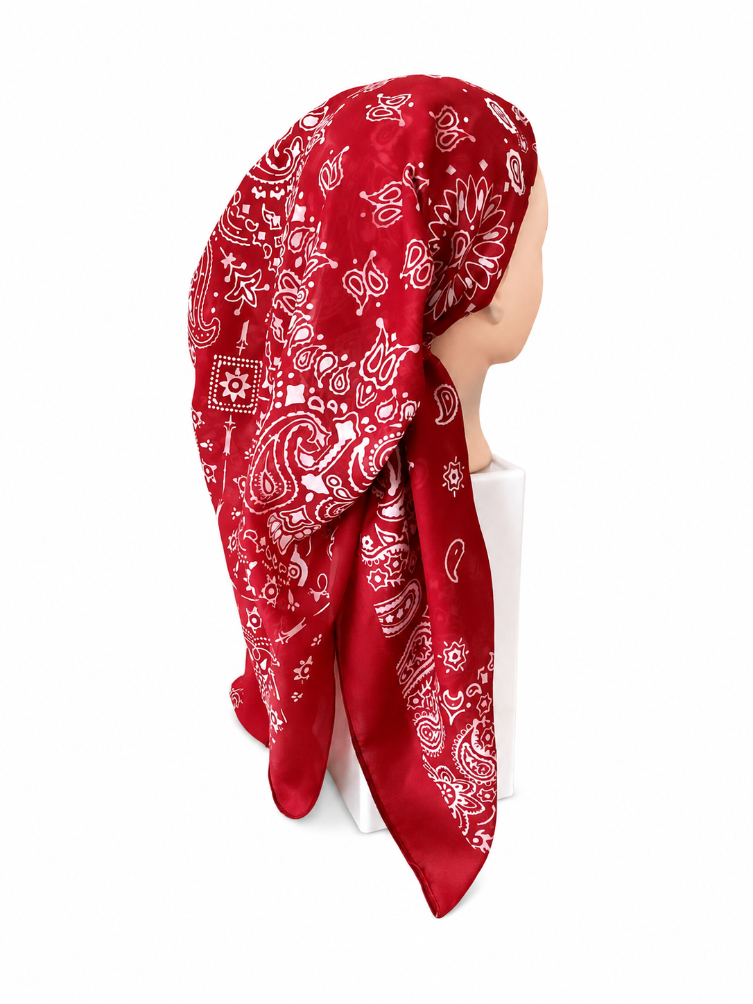 A red bandana with a white paisley pattern, styled on a mannequin head against a plain white background.