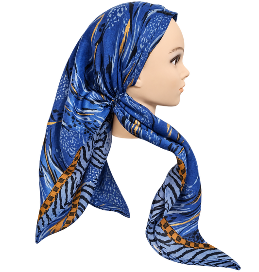 A blue patterned scarf with abstract and zebra-like prints, styled on a mannequin head in profile against a plain white background.