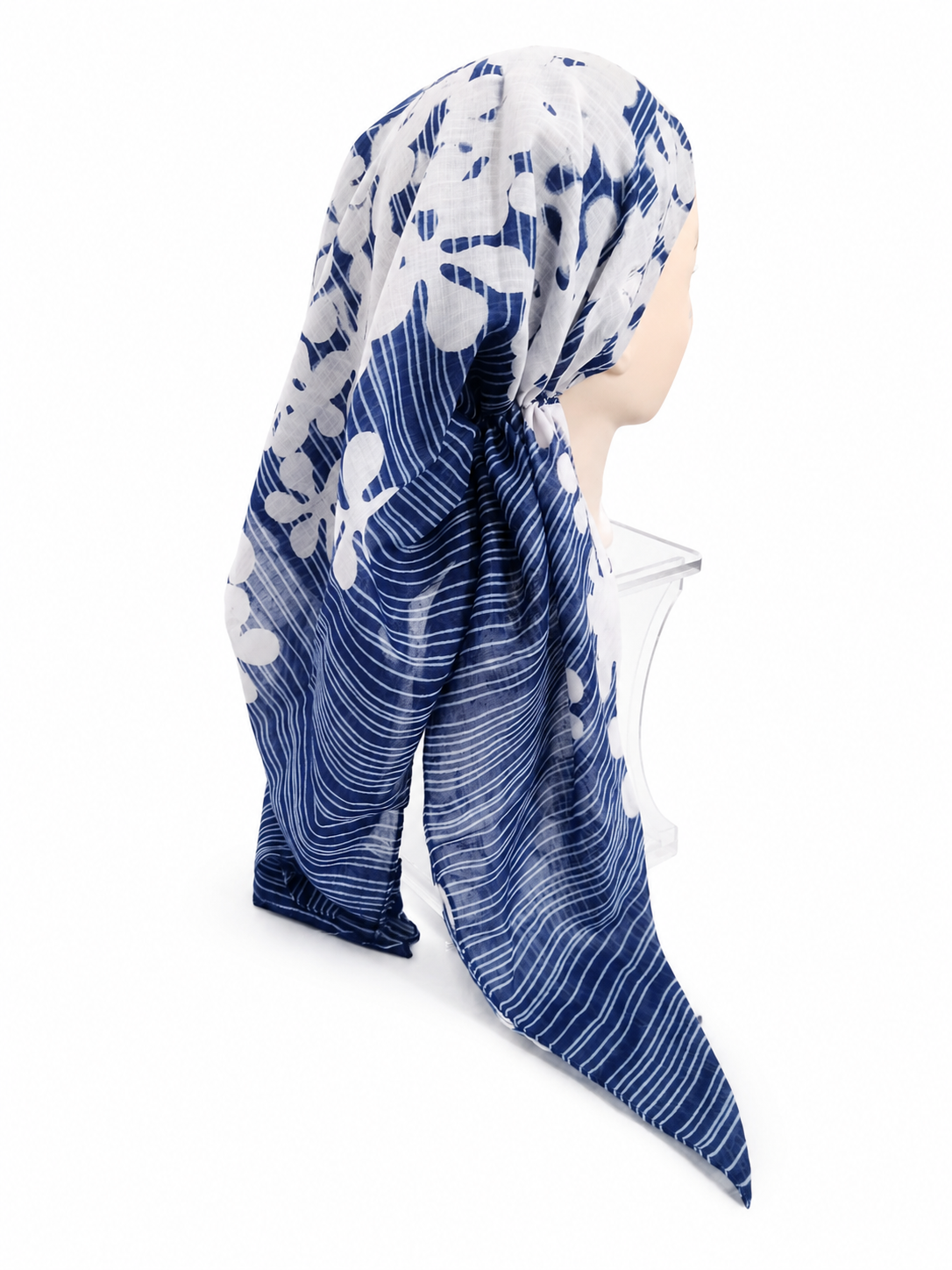A blue and white patterned headscarf draped on a mannequin head against a plain white background.