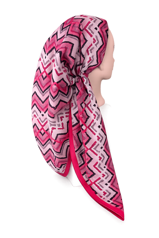 Mannequin head wearing a pink and white patterned pretied tichel on a white background