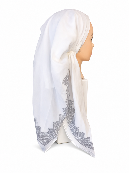 A white headscarf with a gray geometric embroidered border, displayed on a mannequin head in profile against a white background.
