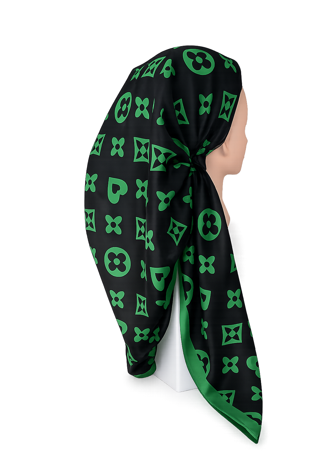 Black scarf with green geometric pattern draped over a mannequin head on a white background