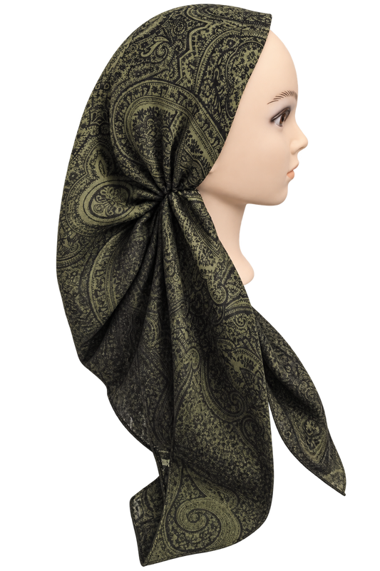 A side-profile view of a mannequin wearing a large headscarf with an intricate paisley pattern in olive green and black, set against a plain white background.