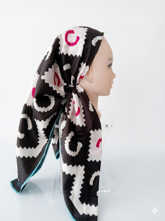Mannequin head wearing a patterned scarf on a white background