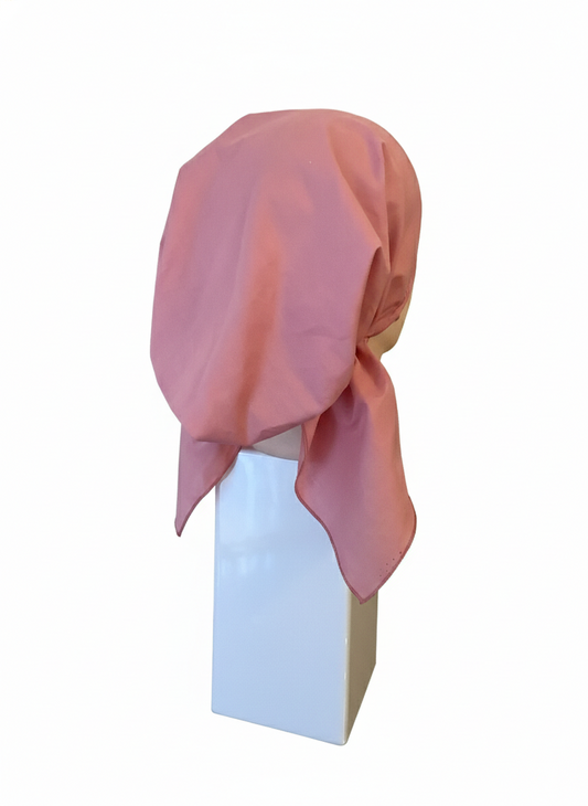 Pink tichel on a mannequin head against a white background