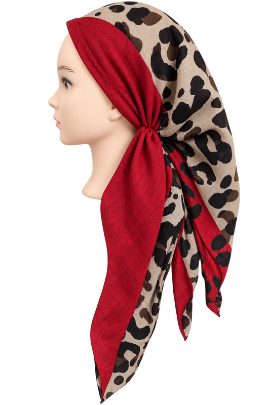 A beige scarf with a black leopard print pattern and solid red panels, styled on a mannequin head in profile against a white background.