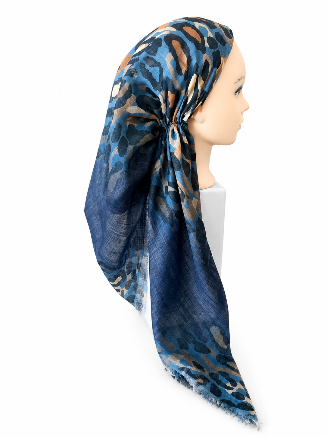 A lightweight square scarf with a blue, brown, and beige leopard print, styled on a mannequin head against a plain white background.