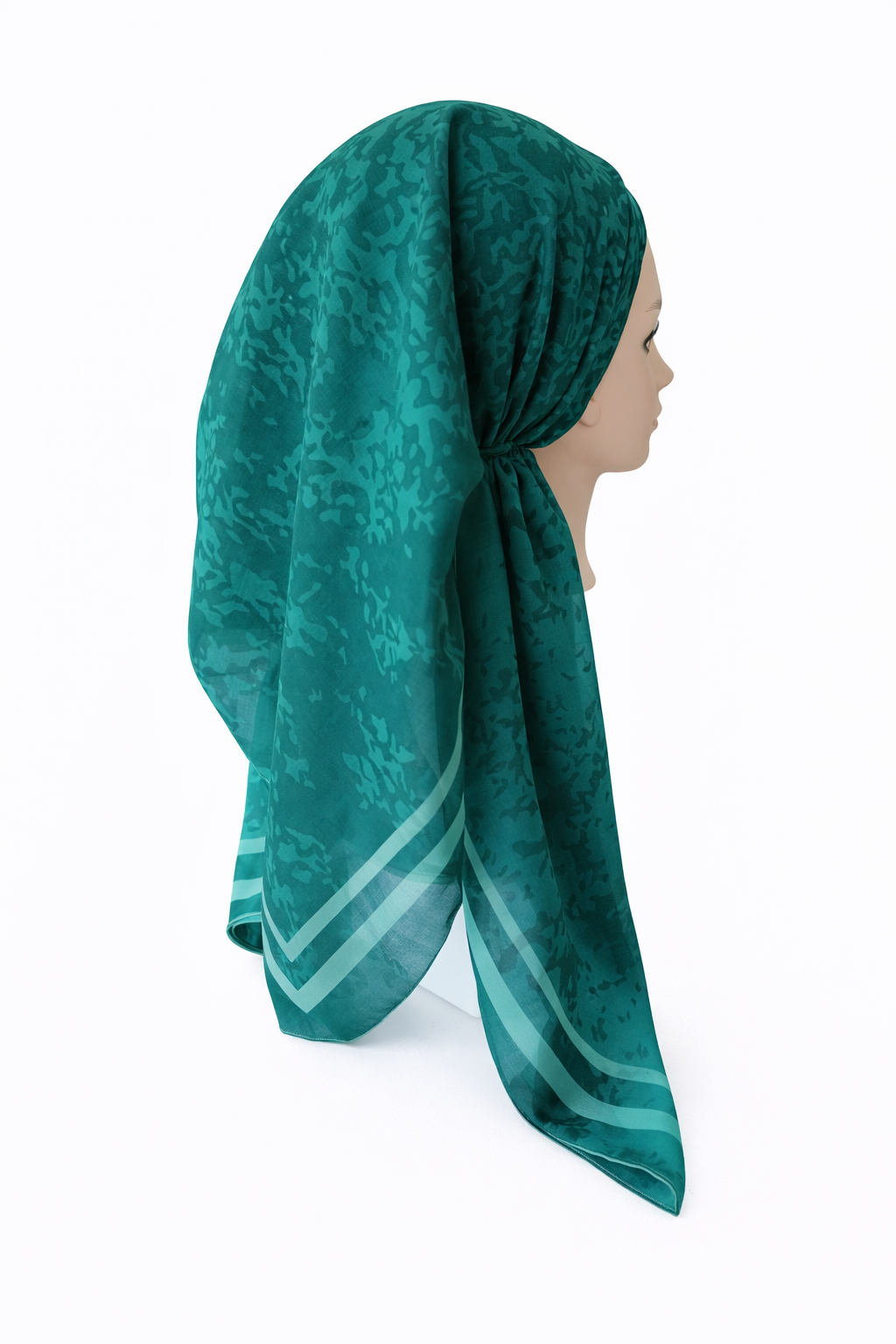 Teal patterned headscarf on a mannequin against a white background