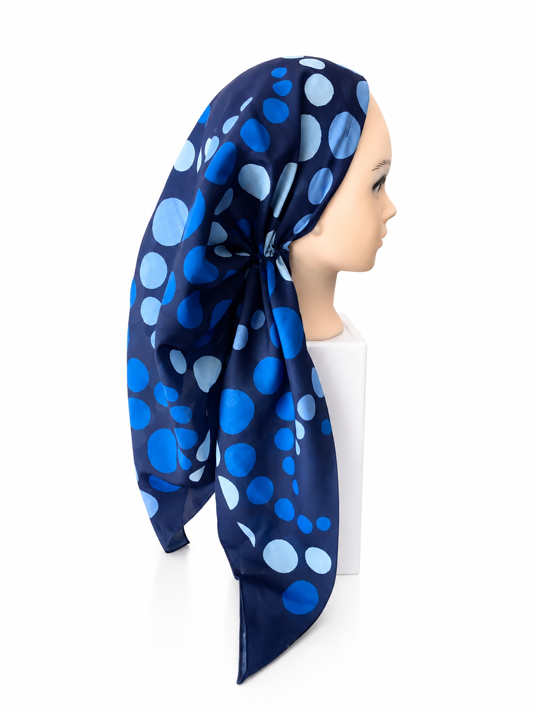 Navy blue headscarf with blue polka dots worn by a mannequin on a white background