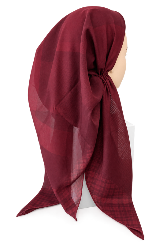 A deep burgundy red plaid scarf draped on a mannequin head against a plain white background.
