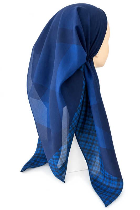 A blue patterned headscarf displayed on a mannequin head against a plain white background.