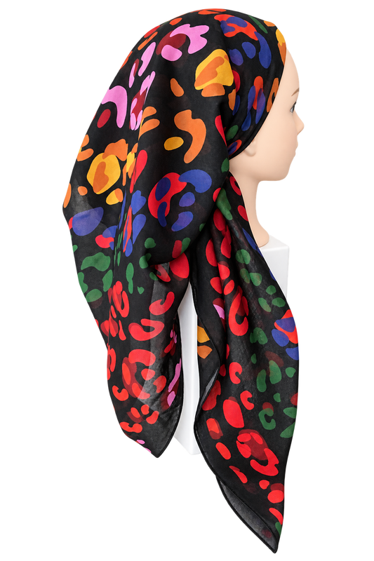 A black scarf with a vibrant multicolor abstract print, styled on a mannequin head against a plain white background.