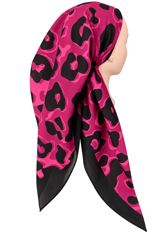 A pink and black leopard print headscarf styled on a mannequin head, shown from a side profile view against a plain white background.