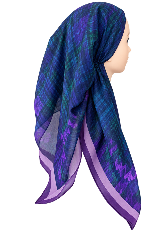 A purple and blue patterned headscarf wrapped on a mannequin head, shown in profile against a plain white background.
