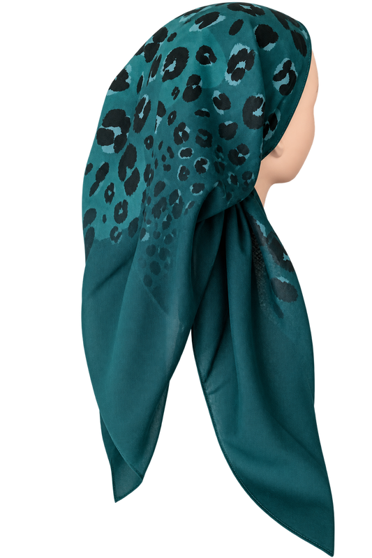 A teal green tichel with a black leopard print pattern, styled on a mannequin head against a plain white background.