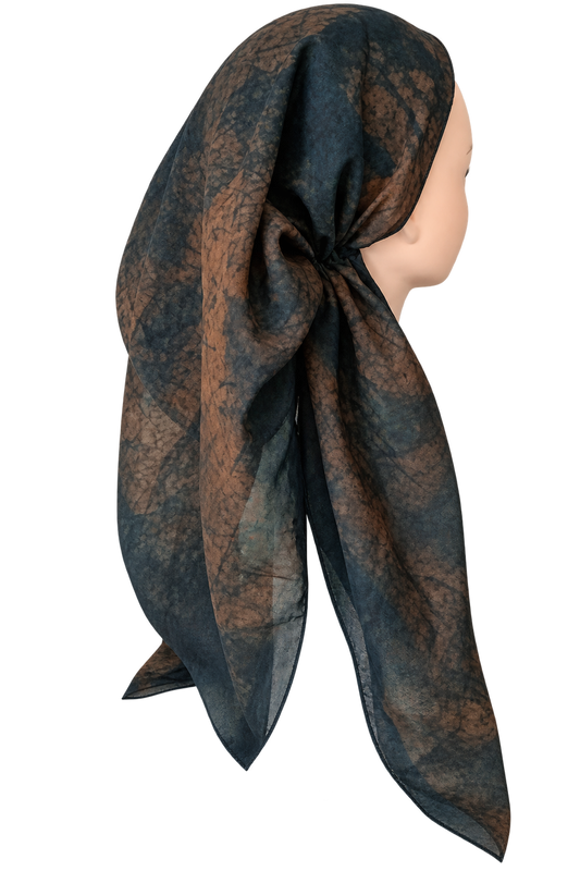 A lightweight square scarf with a mottled abstract pattern in dark teal-blue and brown, styled on a mannequin head against a plain white background.