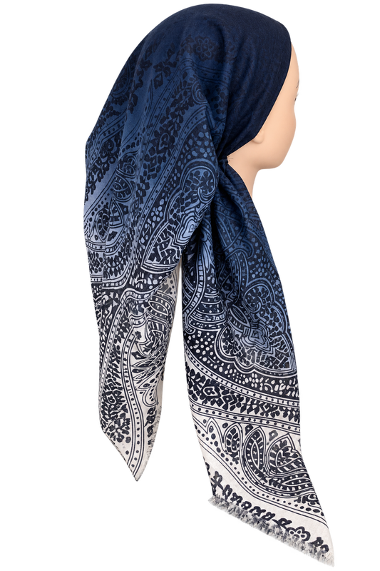 A navy blue and white patterned headscarf draped on a mannequin head, shown from the side against a plain white background.
