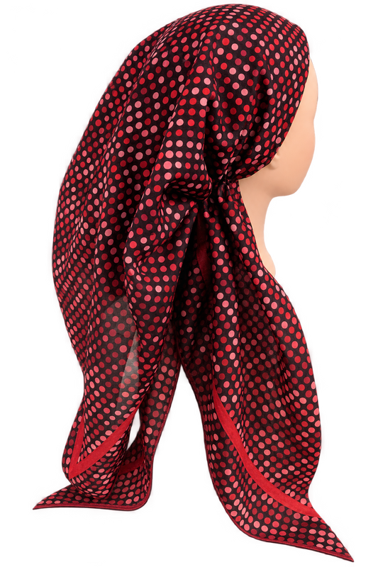 A red and black polka dot scarf styled on a mannequin head, shown from a side profile against a solid white background.