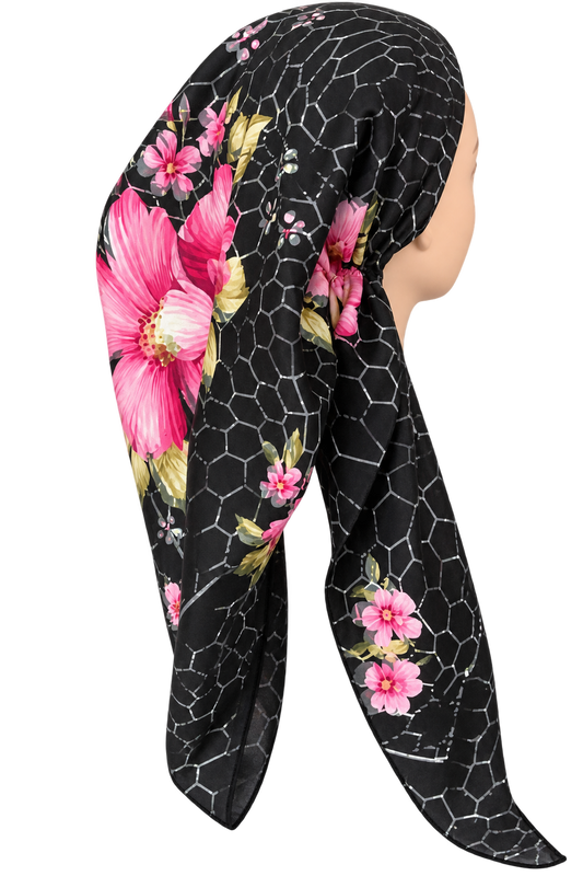 A black pretied tichel with a pink floral print and a white geometric honeycomb pattern, styled on a mannequin head against a white background.