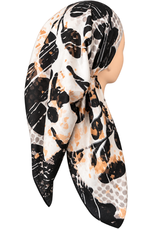A square scarf with an abstract floral and brushstroke pattern in black, white, and warm orange, styled on a mannequin head against a plain white background.