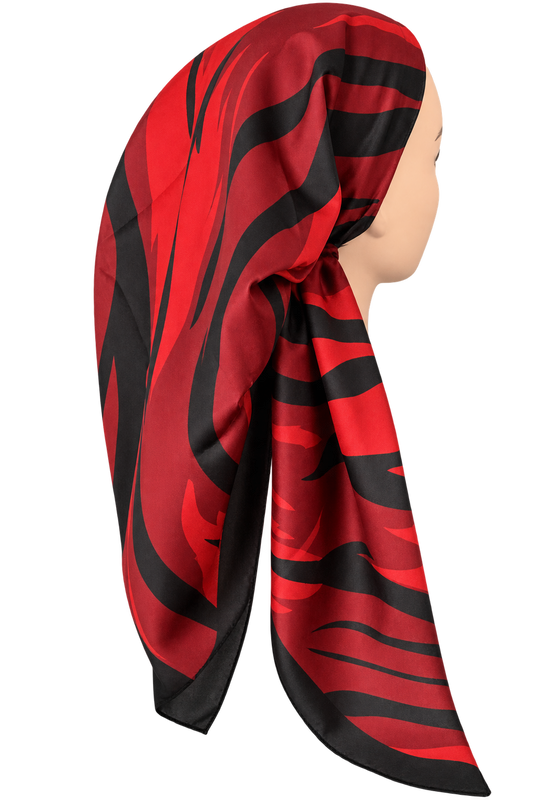 A red and black patterned silk headscarf styled on a mannequin head against a solid white background.