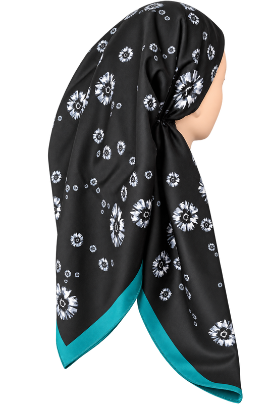 A black silk-like headscarf with a white floral pattern and a bright teal border, styled on a mannequin head against a plain white background.