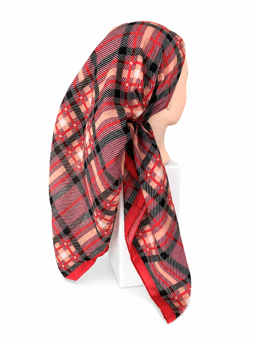 A red, black, and beige plaid scarf wrapped around a mannequin head, displayed on a white stand against a white background.