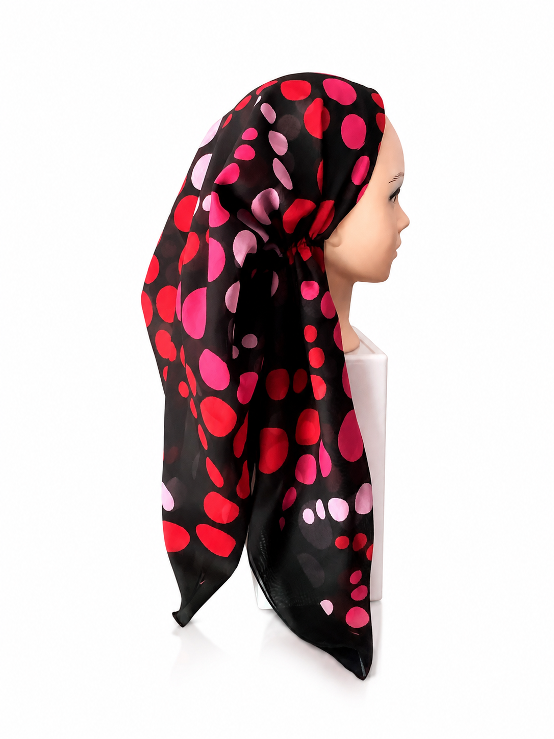 Black pretied tichel with pink and red polka dots worn by a mannequin on a white background