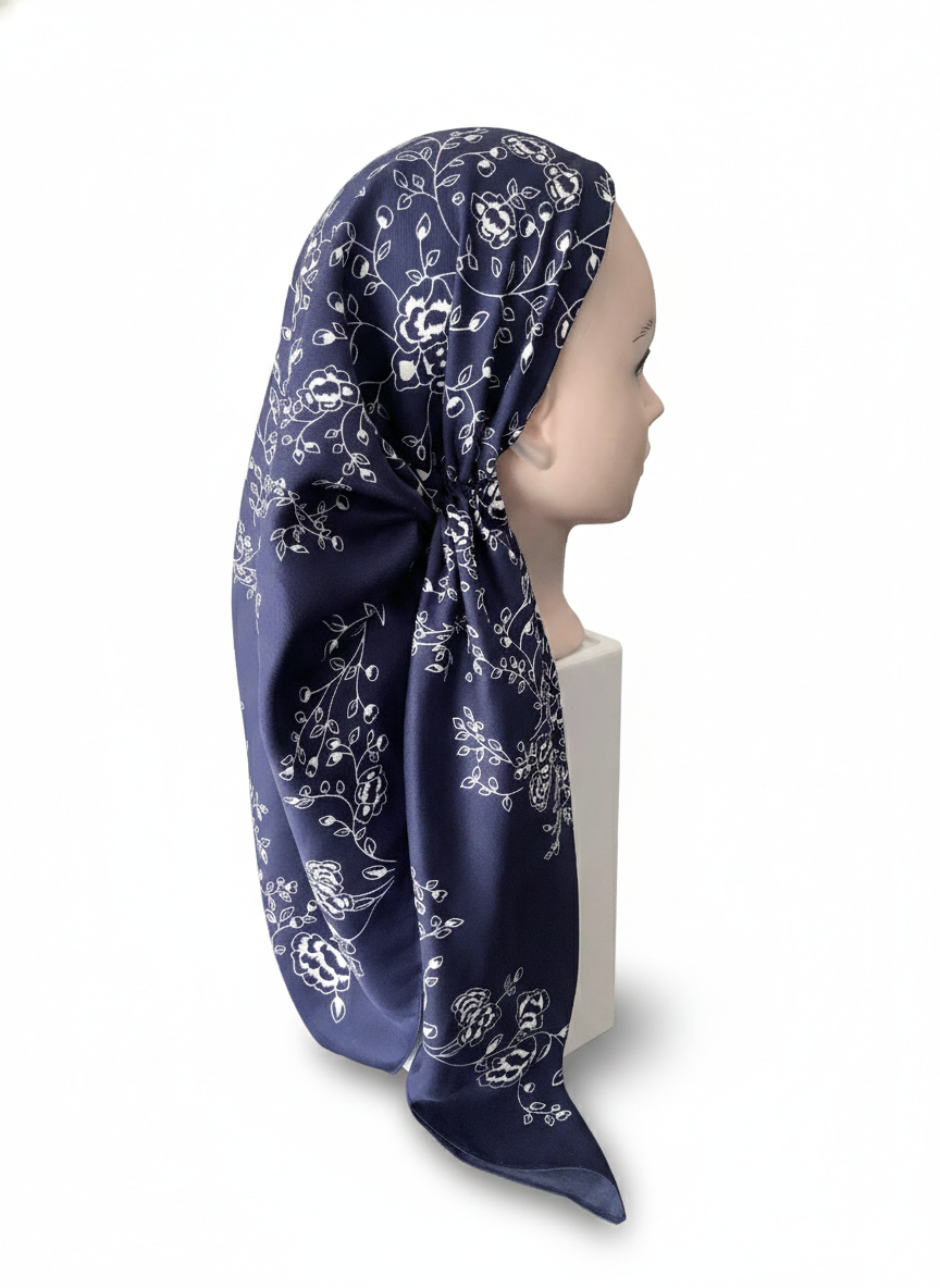 Navy blue headscarf with white floral pattern on a mannequin head against a white background