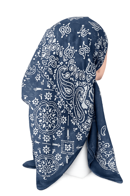A navy blue and white paisley bandana headscarf draped on a white mannequin head against a plain white background.